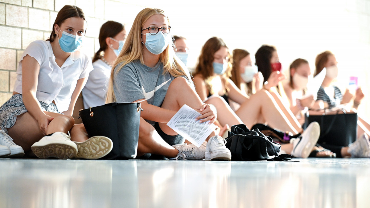 Diákok védőmaszkban hallgatják a tanítás újraindításával kapcsolatos tájékoztatást egy középiskola tornatermében Duisburgban 2020. augusztus 12-én, a koronavírus-járvány idején. Észak-Rajna-Vesztfália tartományban 2,5 millió tanuló kezdte meg az új tanévet ezen a napon.