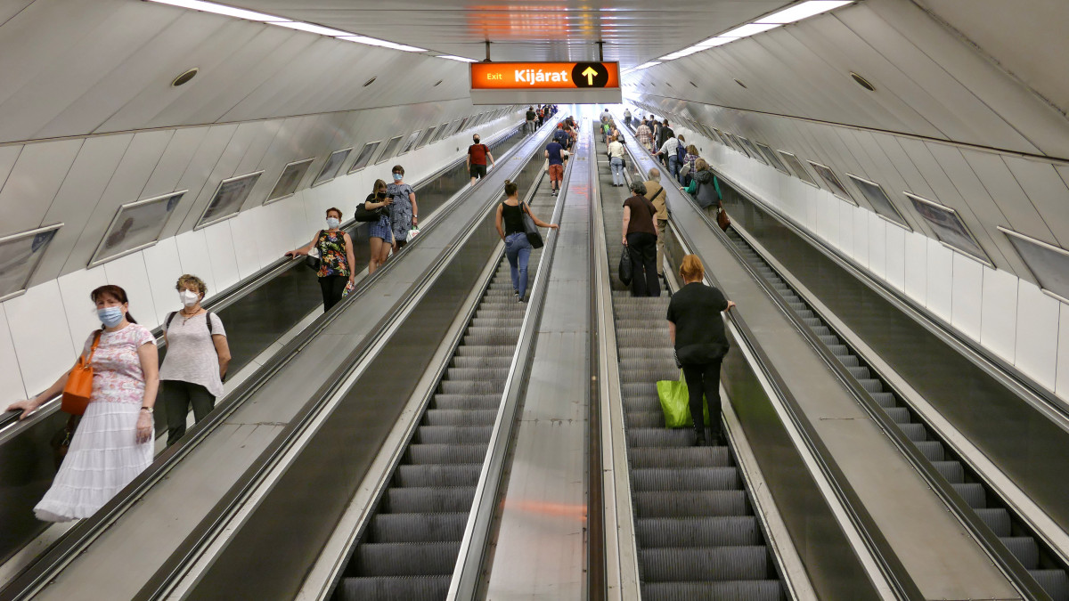 Pandémia idején védőmaszkot viselő utasok tartanak mozgólépcsőn a Budapesti Közlekedési Központ (BKK)  2-es metró vonalához a Széll Kálmán térnél. MTVA/Bizományosi: Jászai Csaba  *************************** Kedves Felhasználó!