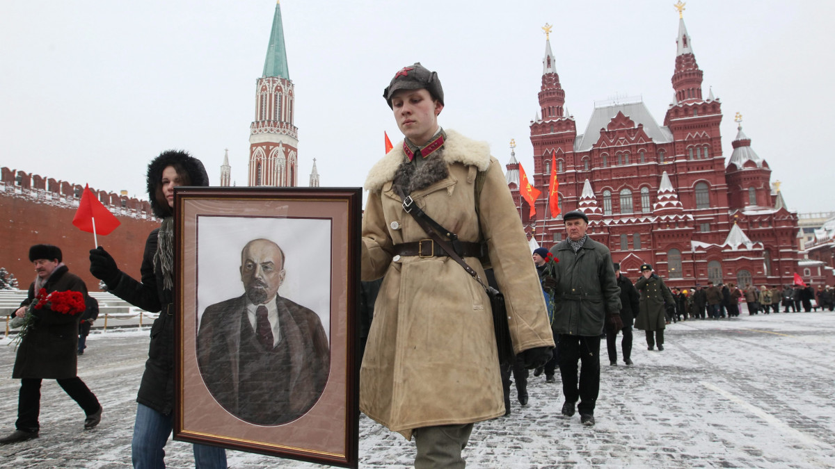 Orosz kommunisták óriási Lenin-portréval a kezükben érkeznek a Lenin-mauzóleum elé a moszkvai Vörös téren az egykori Szovjetunió zászlójával a kezükben 2011. január 21-én, a szovjet állam alapítójának, Vlagyimir Iljics Lenin halálának 87. évfordulóján. 