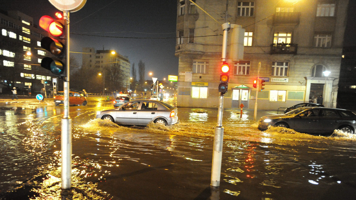 Autók haladnak a XIII. kerületi Szegedi út és Béke út kereszteződésében, miután eltörött egy főnyomócső a Béke tér közelében. Három parkoló autó alatt szakadt be az úttest, kettőnek csak a kerekei alól mosta ki az utat a feltörő víz, egy viszont el is tűnt a háromszor négyméteres üregben.