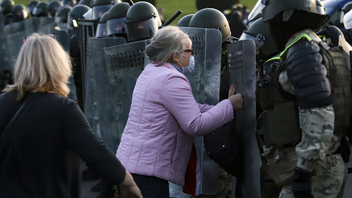 Rohamrendőrökkel vitatkozó nő egy tüntetésen Minszkben 2020. szeptember 23-án, miután Aljakszander Lukasenka fehérorosz elnök letette hivatali esküjét az államfői rezidencián, a Függetlenség Palotájában. Fehéroroszországban augusztus eleje óta tüntetnek, mert a tiltakozók szerint Lukasenka csalással győzött a választásokon. 
