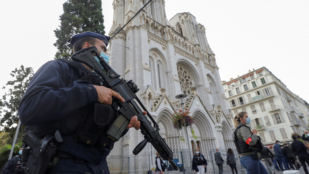 Gépfegyveres rendőr áll a nizzai Notre-Dame-bazilikánál 2020. október 29-én. Brahim Ausszaui 21 éves tunéziai bevándorló a reggeli órákban késsel támadt a bazilikában tartózkodó három emberre, egy idős nőt lefejezett, a sekrestyést és egy másik nőt halálosan megsebesített. Franciaországban a legmagasabb szintre emelték a terrorkészültséget a támadást követően.