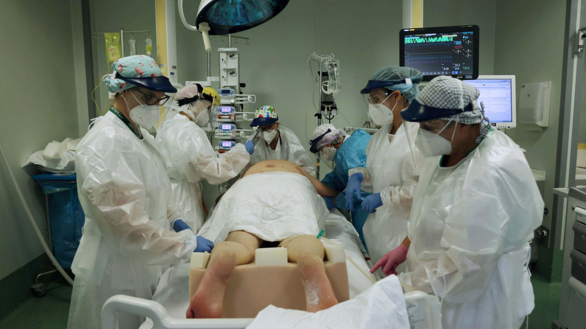 Védőmaszkot és arcpajzsot viselő egészségügyi dolgozók látnak el egy beteget a koronavírus-fertőzöttekkel foglalkozó intenzív osztályon egy bergamói kórházban 2020. november 3-án.