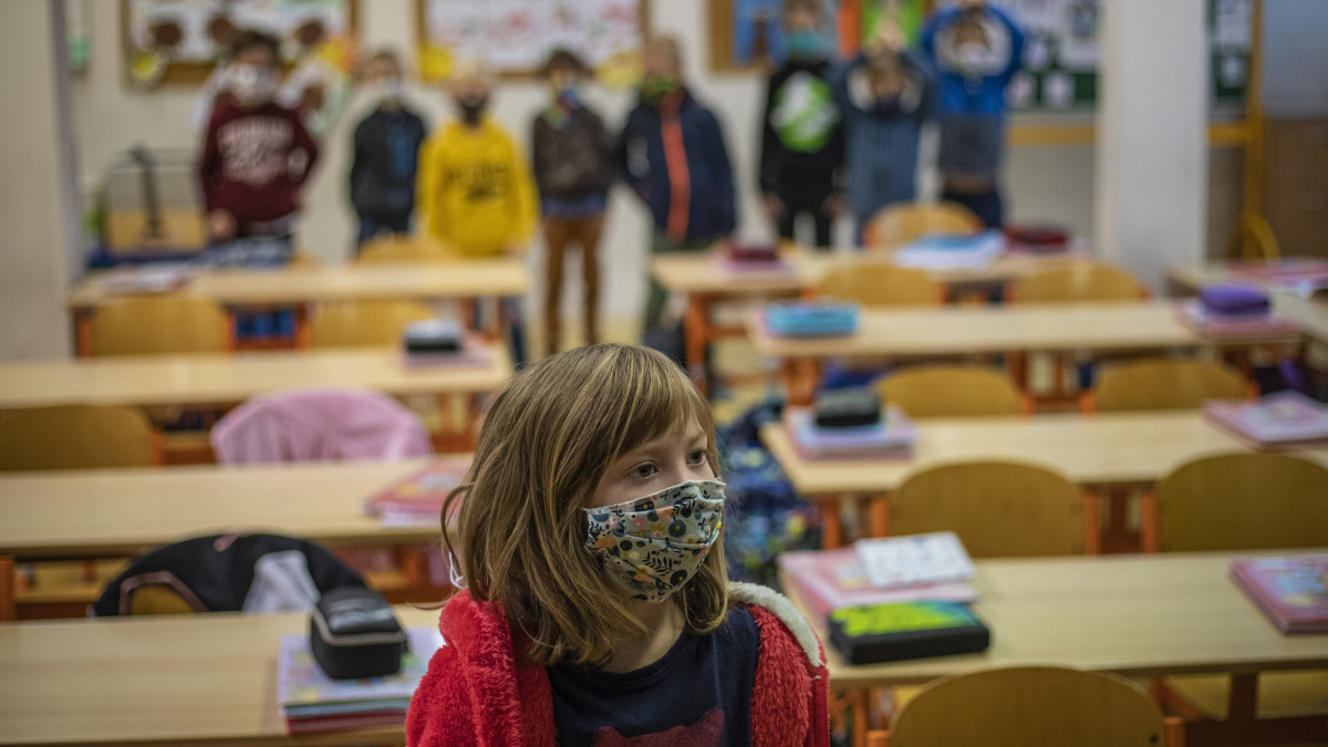 A koronavírus-járvány miatt védőmaszkot viselő tanuló egy prágai iskolában 2020. november 18-án, amikor az általános iskolák első és második osztályosai visszatérhettek az osztálytermekbe. A járvány miatt a cseh kormány október 14-től minden iskolában elrendelte az áttérést a digitális oktatásra.