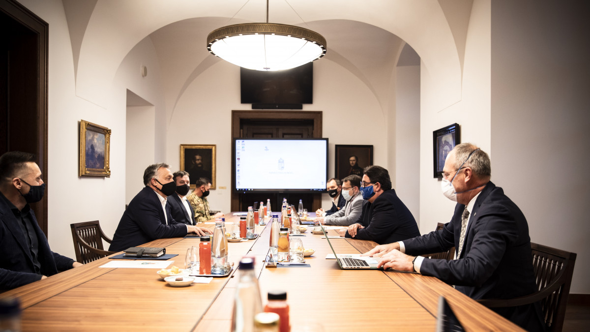 A Miniszterelnöki Sajtóiroda által közreadott képen Orbán Viktor miniszterelnök (b2) járványügyi szakemberekkel egyeztet, mellette Rogán Antal, a Miniszterelnöki Kabinetirodát vezető miniszter (b) és Palkovics László innovációs és technológiai miniszter (b3) a Karmelita kolostorban 2020. december 3-án. A megbeszélésen részt vett Merkely Béla, a Semmelweis Egyetemen rektora (j2), Szócska Miklós, a Semmelweis Egyetem egészségügyi közszolgálati karának dékánja (j), Röst Gergely, a Szegedi Tudományegyetem járványtannal foglalkozó matematikusa (b3) és Szlávik János, a Dél-pesti Centrumkórház - Országos Hematológiai és Infektológiai Intézet osztályvezető főorvosa (b4).