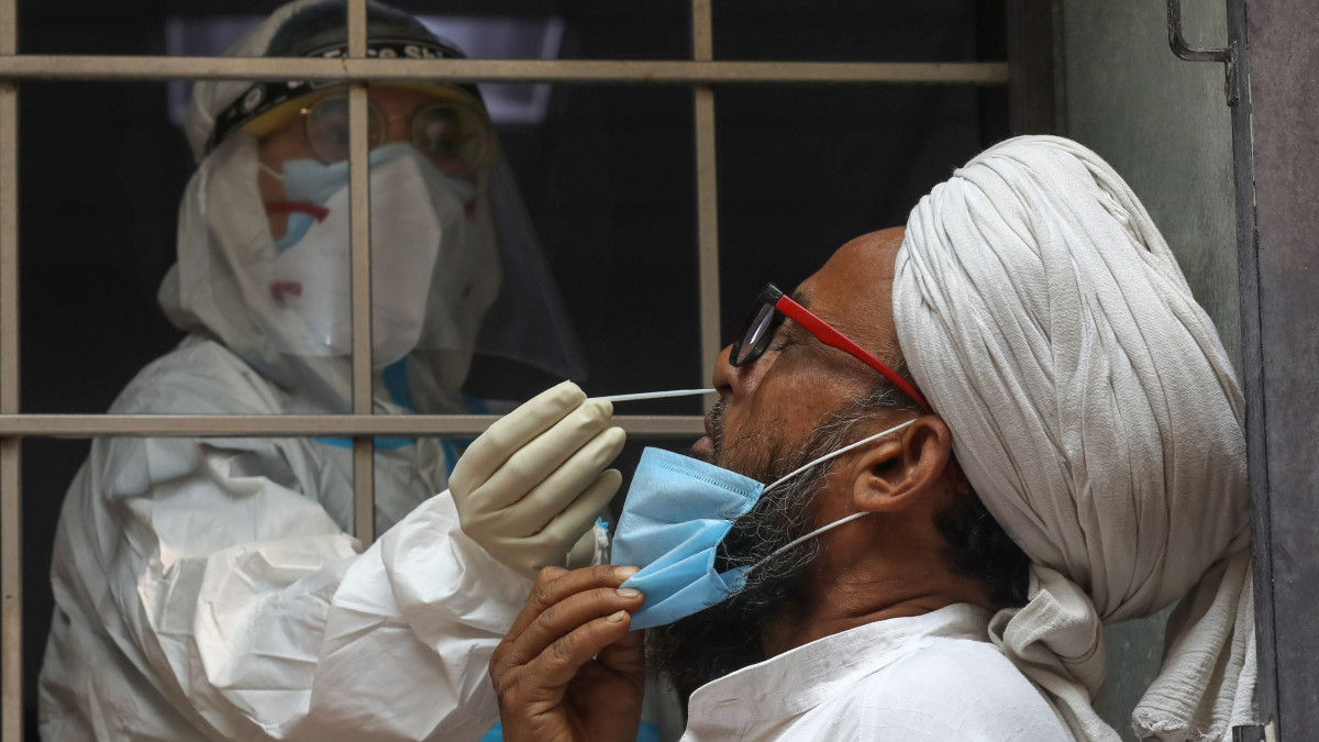 Koronavírus-vizsgálathoz vesznek mintát egy férfitől az indiai fővárosban, Újdelhiben 2020. október 29-én. Indiában az igazolt vírusfertőzöttek száma nyolcmillió fölé emelkedett, itt van a második legtöbb fertőzött a világon.