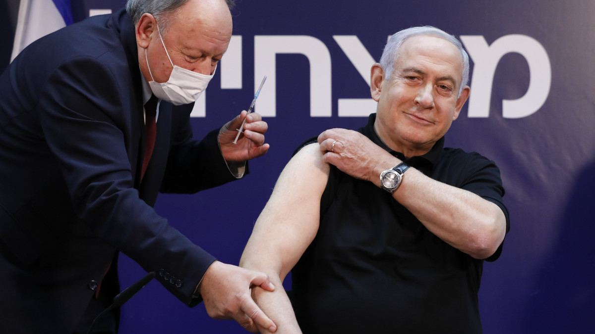 Benjámin Netanjahu izraeli miniszterelnök (j) megkapja a koronavírus elleni védőoltást az izraeli Ramat Gan egyik kórházában 2020. december 19-én.