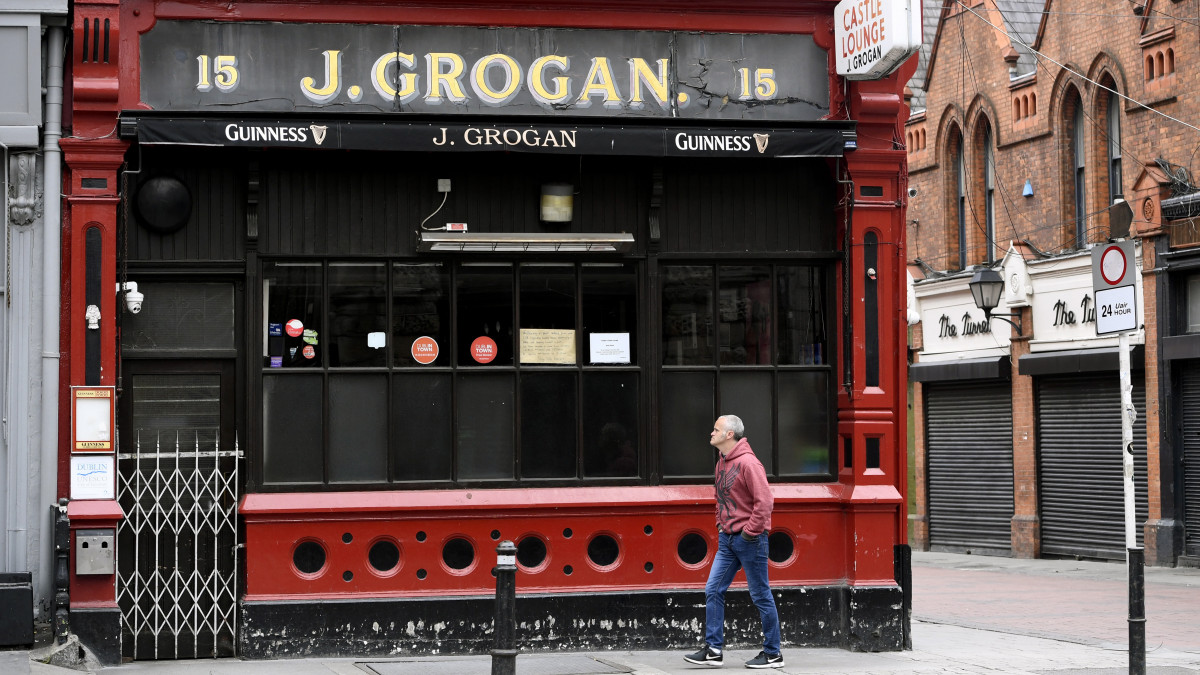 Bezárt söröző előtt halad el egy férfi Dublinban 2020. április 22-én. Paschal Donohoe ír pénzügyminiszter bejelentette, hogy a koronavírus-járvány miatt az ország GDP-je várhatóan 10%-kal fog csökkeni, a munkanlküliség pedig el fogja érni a 22%-ot.
