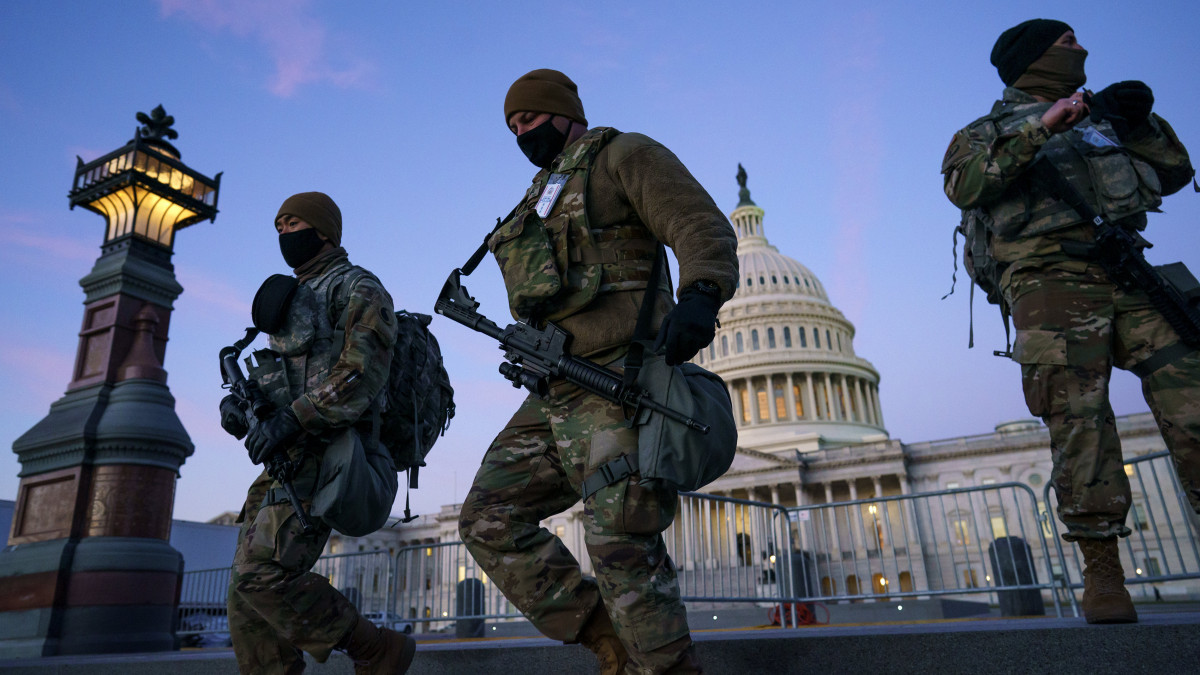 Felfegyverzett katonák járőröznek a washingtoni Capitolium körüli biztonsági zónában 2021. január 19-én. A Capitolium január 6-i ostroma miatt Joe Biden január 20-i beiktatási ünnepségét a nemzeti gárda 25 ezer katonája biztosítja.