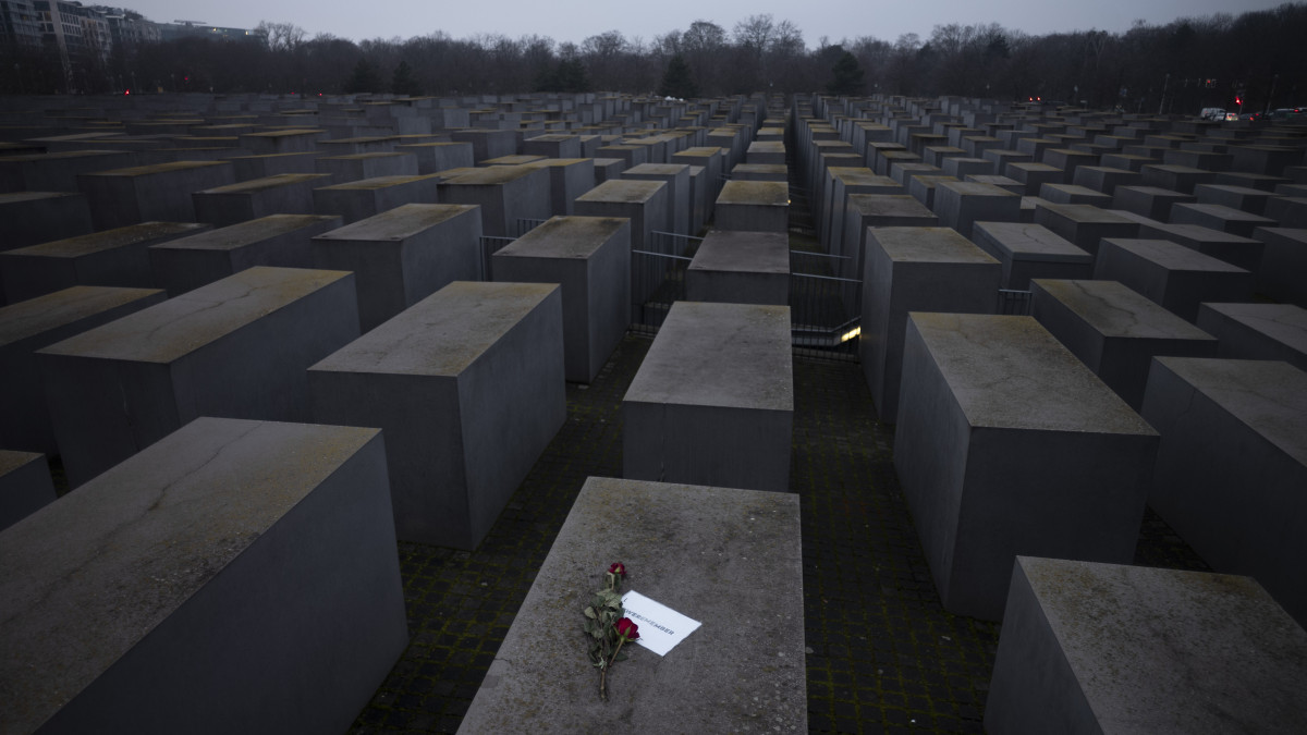 Egy szál rózsát helyeztek egy Emlékezünk feliratú cédulára a nácizmus 6 millió európai zsidó áldozatának emléket állító holokauszt-emlékmű betontömbjeinek egyikén Berlinben 2021. január 27-én, az egykori auschwitz-birkenaui náci koncentrációs tábor felszabadulásának 76. évfordulóján, a holokauszt nemzetközi emléknapján.