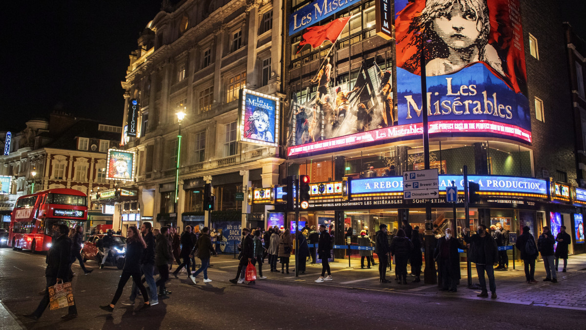 Nézők várakoznak az előadás kezdetére a Sondheim színház előtt a brit főváros Soho negyedében 2020. december 15-én. Matt Hancock brit egészségügyi miniszter bejelentette, hogy december 16-tól a koronavírus-járvány megfékezésére kidolgozott háromfokozatú készenléti rendszer legmagasabb szintje lép életbe Londonban és térségében az új fertőződések számának növekedése miatt.