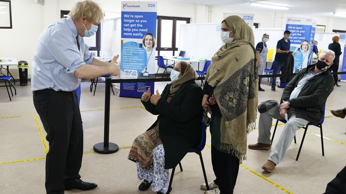 Boris Johnson brit miniszterelnök (b) látogatást tesz a Batley-ban létesített oltóközpontban 2021. február 1-jén.