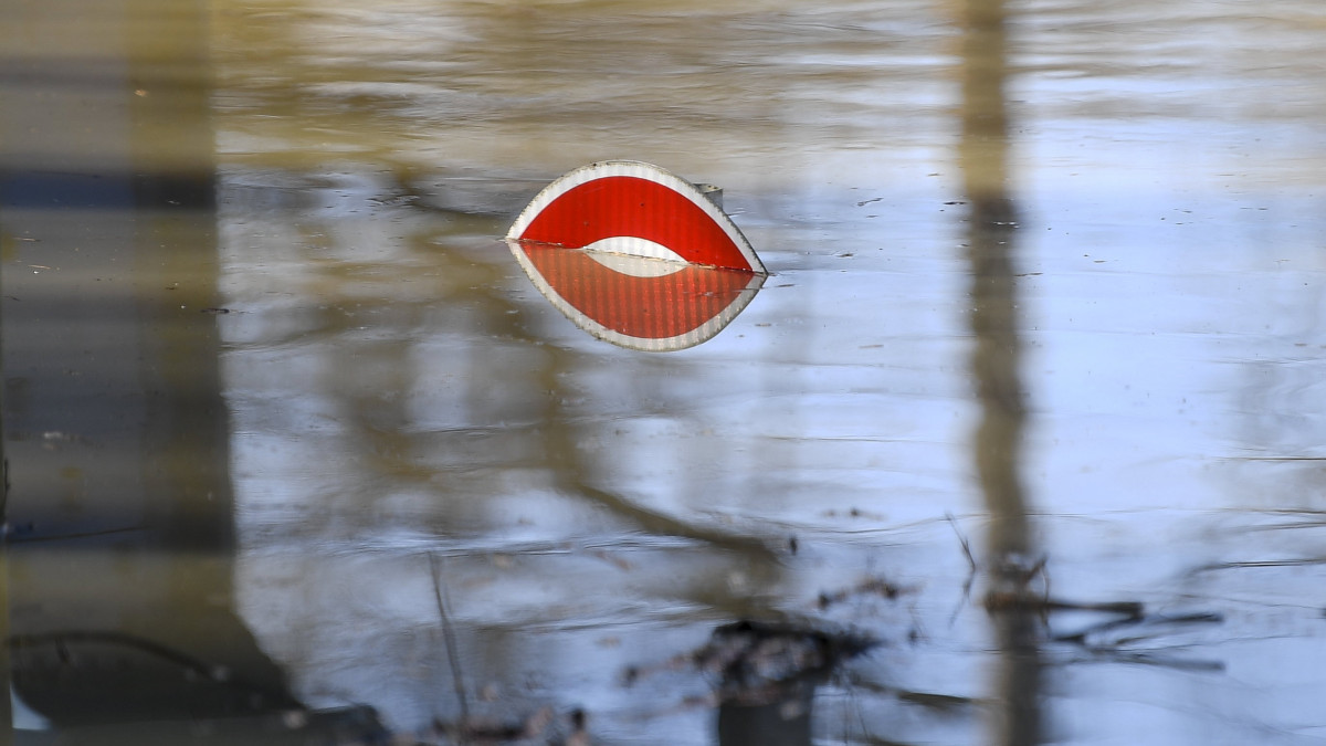 Az áradó Tisza miatt víz alatt lévő közúti jelzőtábla a tiszadobi pontonhídnál 2021. február 15-én.