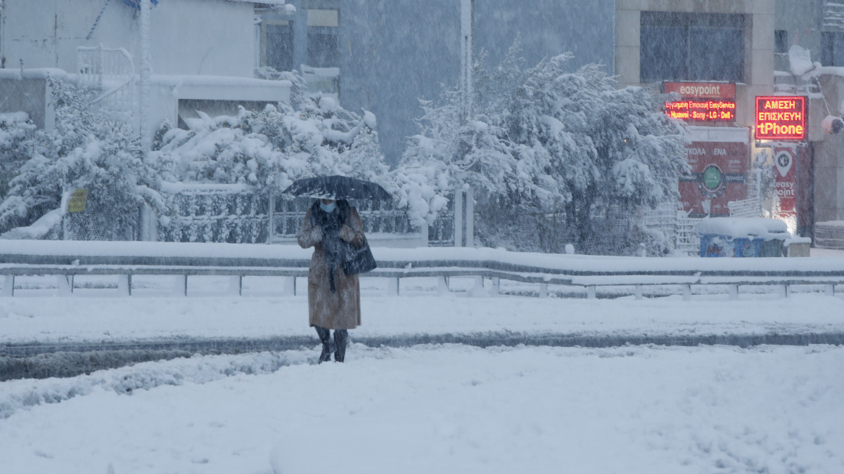 Gyalogos a szakadó hóesésben Athén északi részén 2021. február 16-án.