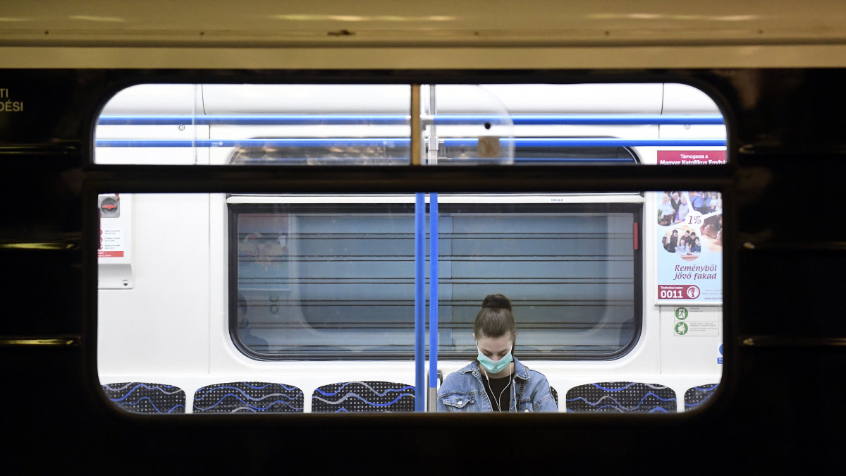Védőmaszkot viselő utas a 3-as metró Deák téri állomásán 2020. március 19-én. A koronavírus-járvány miatt jelentősen csökkent az utazók száma a közösségi közlekedés járatain.