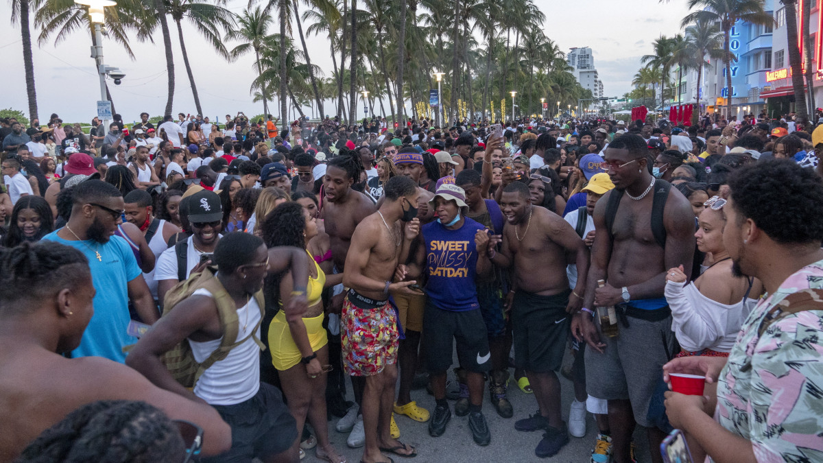 Zsúfolásig tele emberekkel az Ocean Drive nevű népszerű óceánparti sétány a Florida állambeli Miami Beachben 2021. március 20-án, a koronavírus-járvány idején. Miami Beach túlterhelődött a tavaszi szünet miatt ide érkezett több ezer szórakozni vágyó embertől, ezért a városvezetés éjféltől kijárási tilalmat rendelt el este nyolc után a bulinegyedben, a városba vezető utak közül hármat is lezártak.