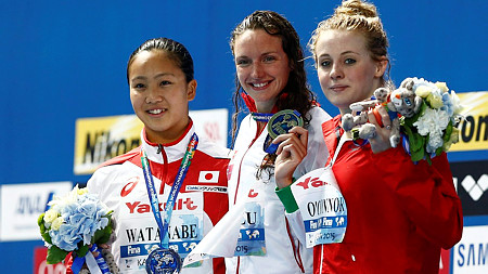 Az aranyérmes Hosszú Katinka az ezüstérmes japán Vatanabe Kanako (b) és a bronzérmes brit Siobhan OConnor között, miután világcsúccsal győzött a kazanyi úszó-, vízilabda-, műugró- és műúszó-világbajnokság női 200 méteres vegyesúszásában 2015. augusztus 3-án.