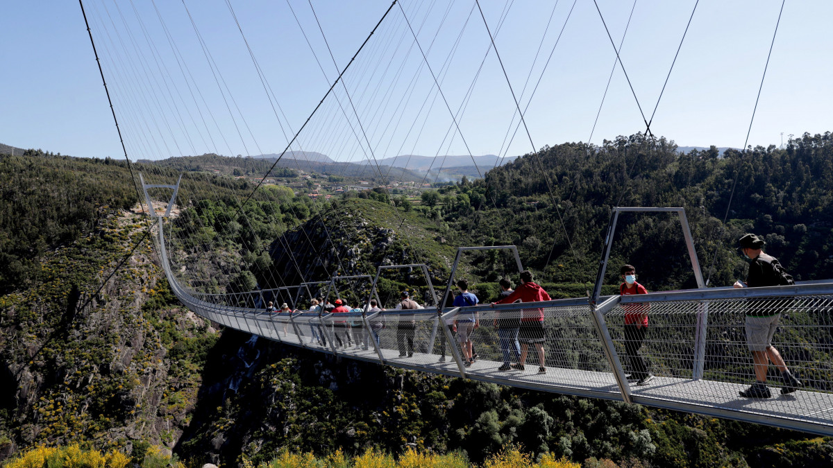 Gyalogosok sétálnak a portugáliai Auroca térségében megépített, 516 méter hosszú, 175 méter magas és 1,20 méter széles függőhídon a Paiva folyó felett 2021. április 16-án. Az 516 Arouca nevet viselő gyalogoshíd Portugália, és egyben a világ leghosszabb függőhídja, amelyet a tervek szerint május 3-án nyitnak meg a nagyközönség előtt.