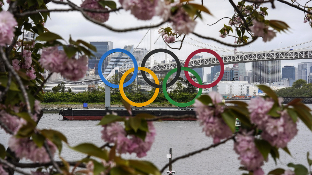 Az olimpiai öt karika a tokiói Odaiba Tengeri Parkban, virágzó cseresznyefaágak között 2021. április 13-án, 101 nappal a tokiói nyári olimpia kezdete előtt. A 2020-as tokiói nyári játékokat a világméretű koronavírus-járvány miatt 2021-re halasztották.