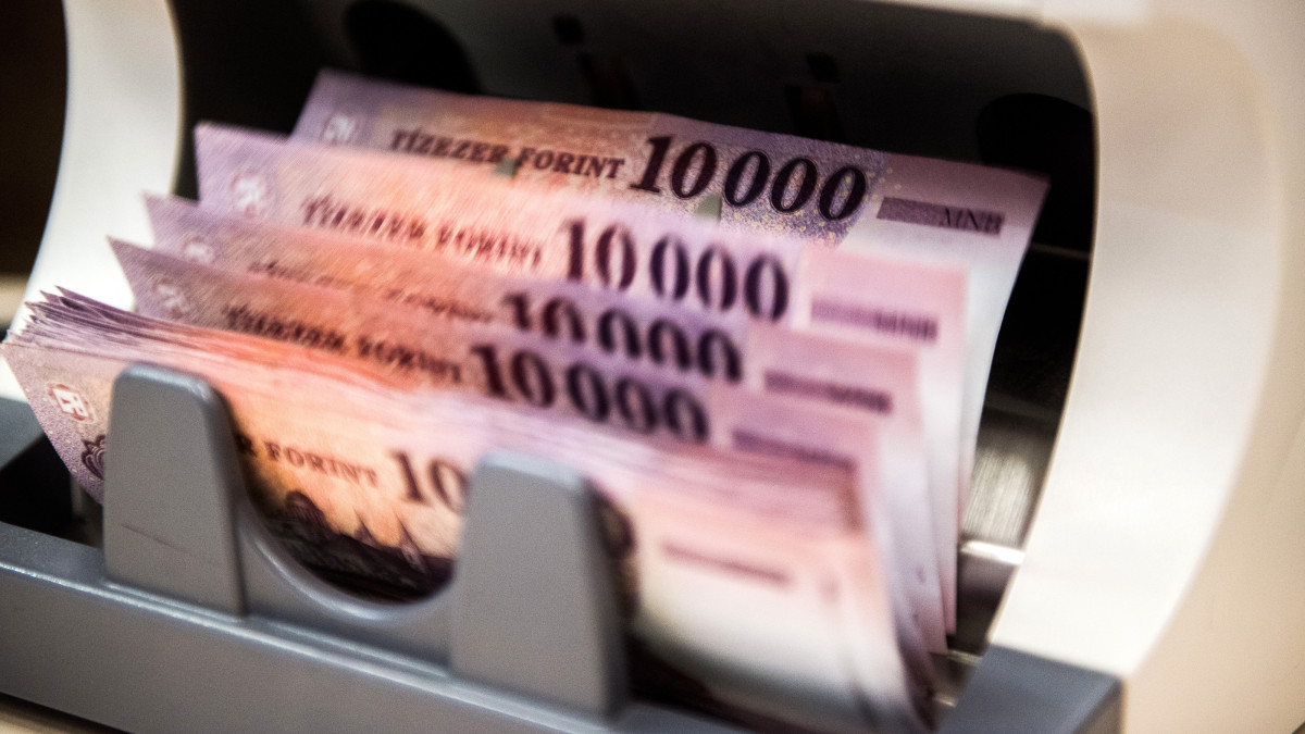 Hungarian ten-thousand Forint banknotes run through a money counting machine at a branch inside the FHB Commercial Bank Ltd, also known as FHB Kereskedelmi Bank Zrt, headquarters in Budapest, Hungary on Tuesday, Nov. 10, 2015. Hungary moved closer to regaining its investment grade status at Moodys Investors Service after Prime Minister Viktor Orbans government helped reduce the countrys debt load and kept the budget deficit in check. Photographer: Akos Stiller/Bloomberg via Getty Images