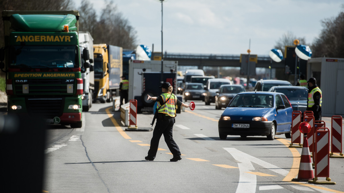 A member of the German police force directs a truck into a holding area to conduct a vehicle search at a control point in Passau, Germany, on Tuesday, March 29, 2016. A permanent return to border controls could lop 470 billion euros of gross domestic product growth from the European economy over the next ten years, based on a relatively conservative assumption of costs, according to research published by Germanys Bertelsmann Foundation. Photographer: Akos Stiller/Bloomberg via Getty Images
