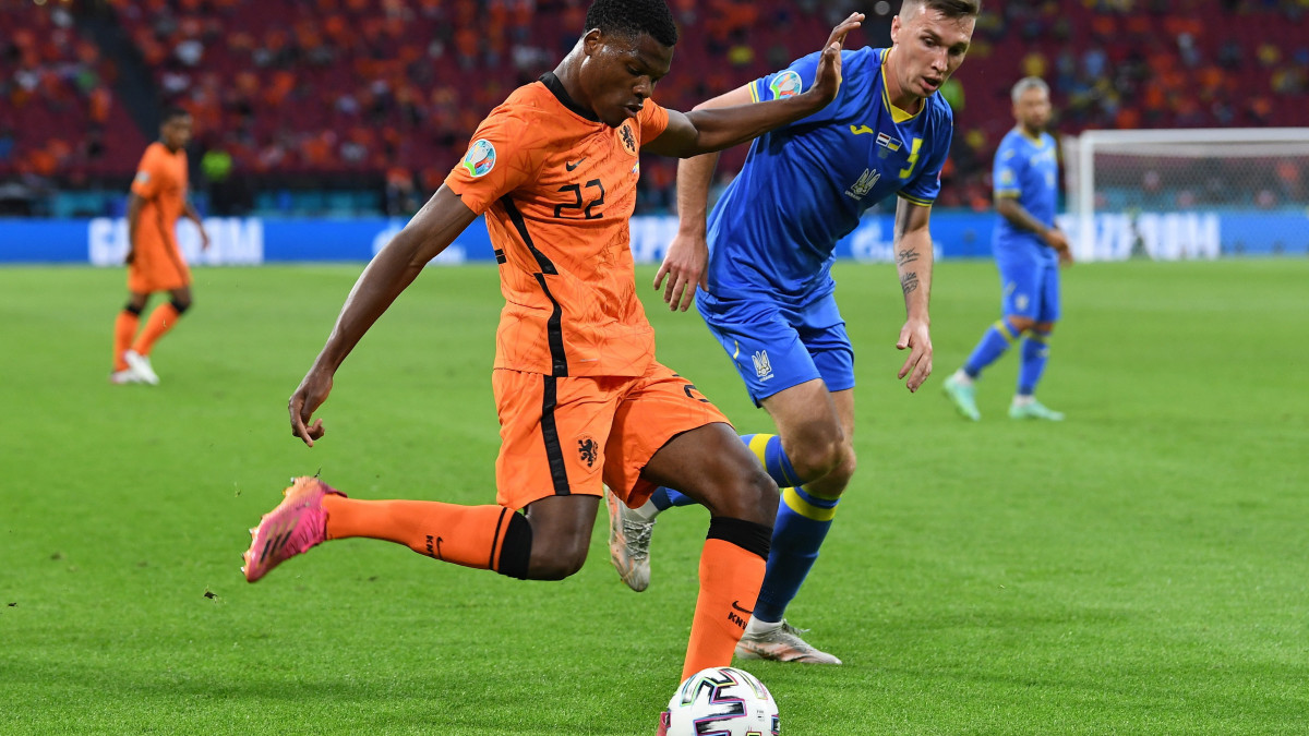 A holland Denzel Dumfries (b) és az ukrán Szerhij Szidorcsuk a világméretű koronavírus-járvány miatt 2021-re halasztott 2020-as labdarúgó Európa-bajnokság C csoportjának első fordulójában játszott Hollandia  Ukrajna mérkőzésen az amszterdami Johan Cruyff Arénéban 2021. június 13-án.