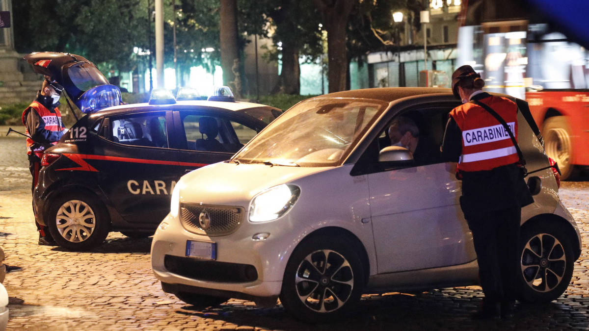 Rendőr ellenőriz egy autóst Rómában a koronavírus-járvány miatt elrendelt kijárási tilalom idején, 2020. november 8-án éjjel.