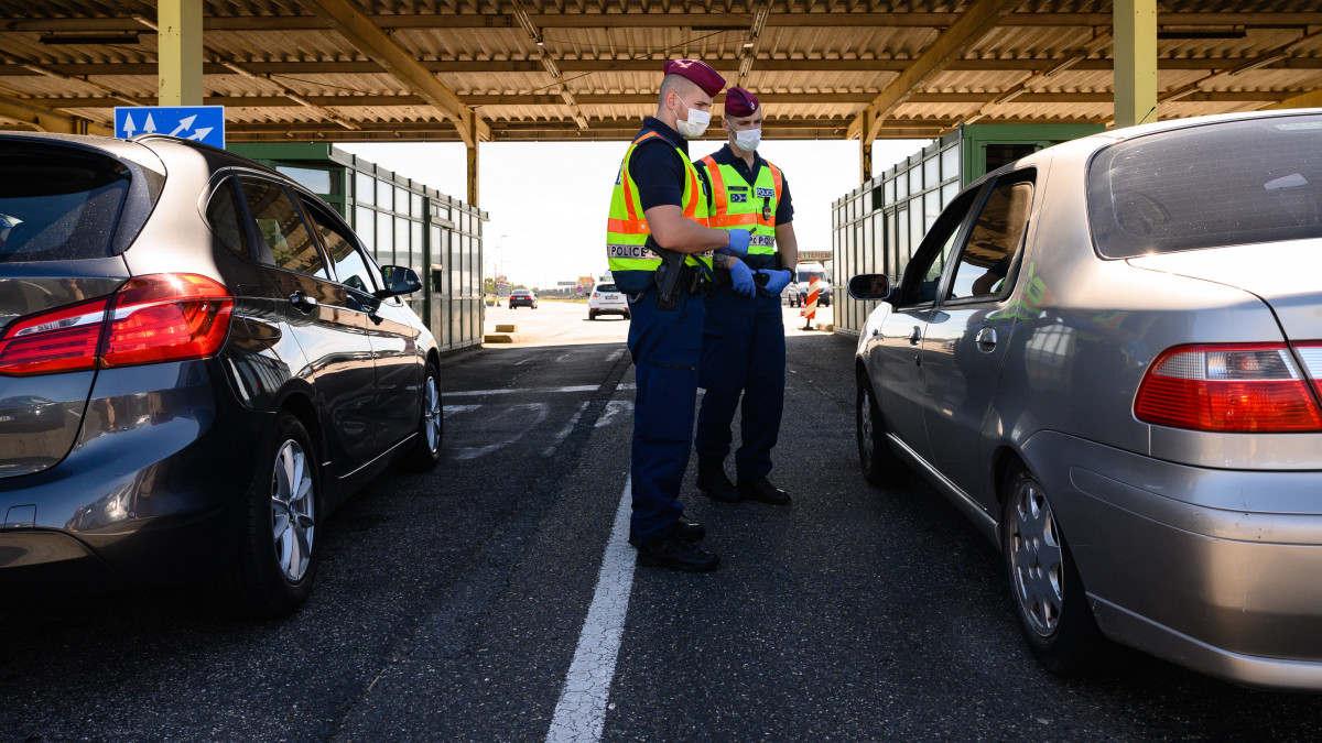 Egy belépő gépjármű utasait ellenőrzik a rendőrök a hegyeshalmi határátkelőnél 2020. szeptember 5-én. A kormány a koronavírus-járvány elleni védekezés részeként szeptember 4-én új szabályokat vezetett be a határátlépésnél. 