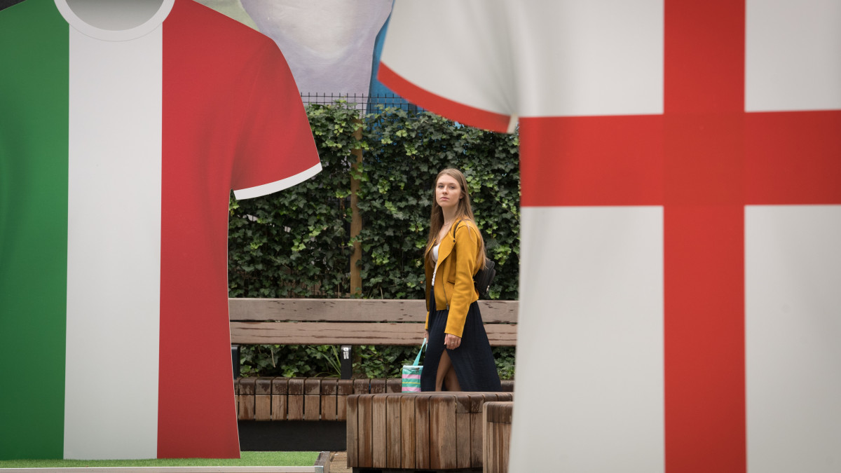 A young woman walks past shirts near Tottenham Court Road in central London representing England and Italy ahead of their clash in the UEFA Euro 2020 final at Wembley Stadium on Sunday evening. Picture date: Thursday July 8, 2021. (Photo by Stefan Rousseau/PA Images via Getty Images)