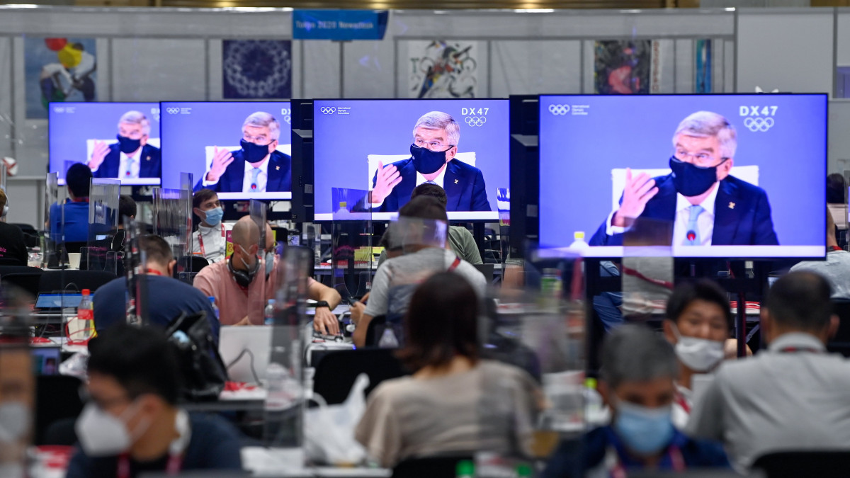 Thomas Bach, a Nemzetközi Olimpiai Bizottság (NOB) elnöke látható televízióképernyőkön az olimpiai médiaközpontban 2021. július 20-án. A világméretű koronavírus-járvány miatt 2021-re halasztott 2020-as tokiói nyári olimpia július 23-án kezdődik.