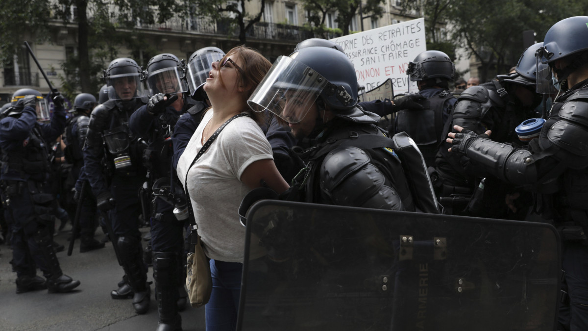 Rohamrendőrök őrizetbe vesznek egy tüntetőt Párizsban 2021. július 31-én. Franciaország több városában is tüntettek a koronavírus elleni oltás felvételét igazoló oltási igazolvány ellen, amellyel bizonyos szolgáltatásokat könnyebben igénybe vehetnek a már beoltott emberek.