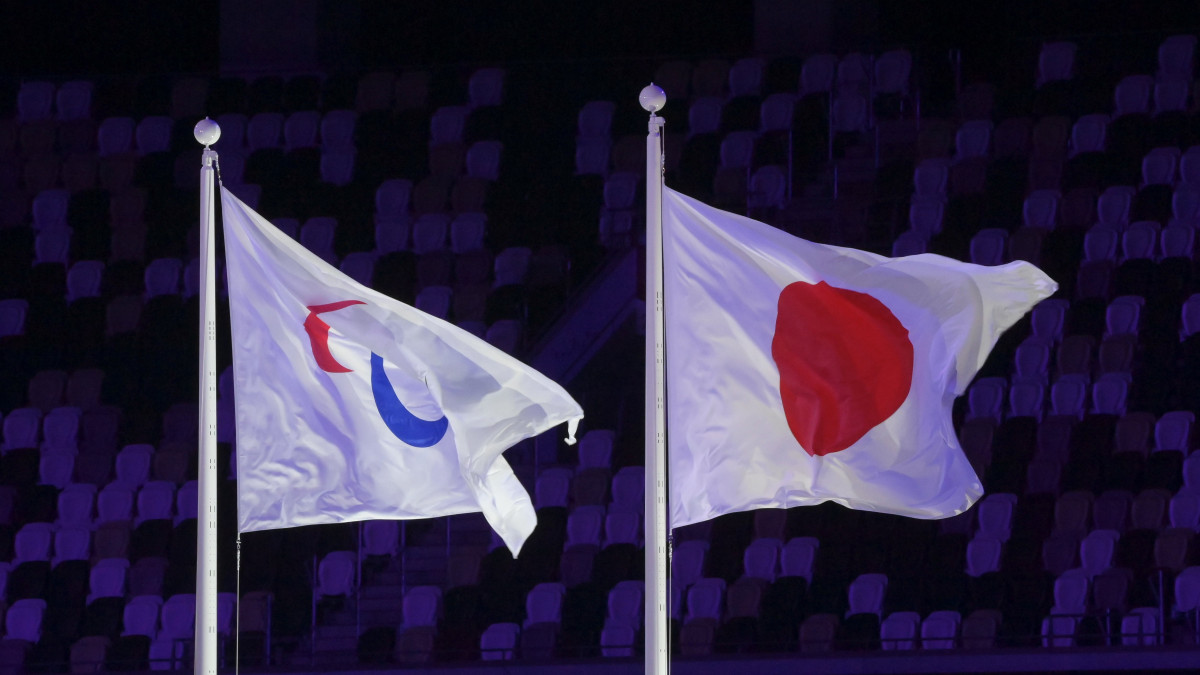 A felvont olimpiai és a japán zászló a világméretű koronavírus-járvány miatt 2021-re halasztott 2020-as tokiói paralimpiai játékok nyitóünnepségén az Olimpiai Stadionban 2021. augusztus 24-én.