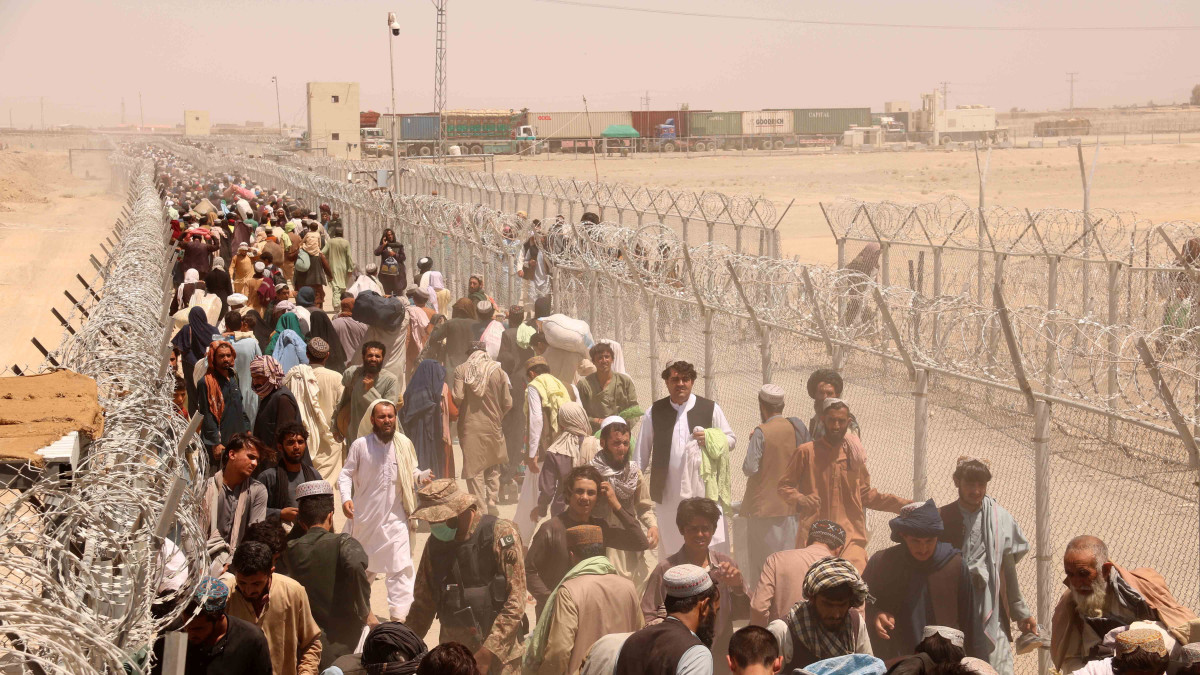 Az afgán-pakisztáni átkelőnél rekedt emberek tolonganak a határ pakisztáni oldalán Csamanban 2021. augusztus 13-án, miután a pakisztáni hatóságok elrendelték a radikális iszlamista tálib harcosok és a kormányerők összecsapása miatt egy hete lezárt átkelő azonnali megnyitását.