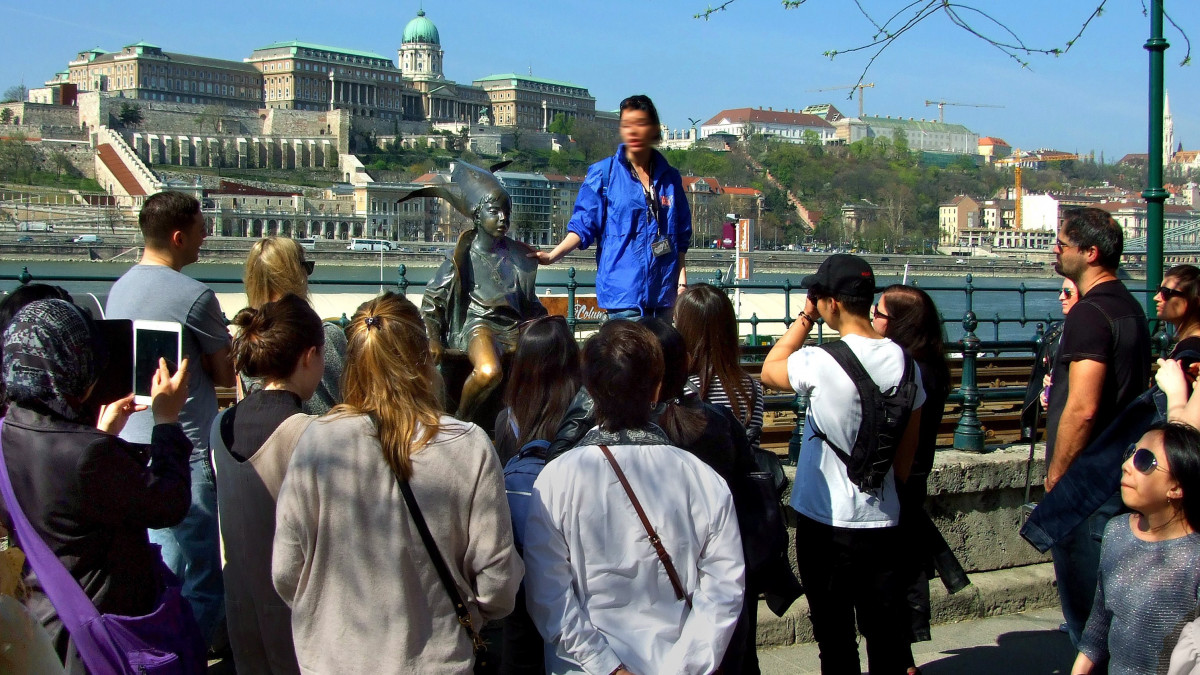 Idegenvezető külföldi turistáknak mutatja be Marton László Kossuth- és Munkácsy-díjas szobrászművész 1990-ben készült Kiskirálylány c. szobrát a Duna-korzón, majd pedig a budai panoráma jeles épületeit.  MTVA/Bizományosi: Jászai Csaba  *************************** Kedves Felhasználó!