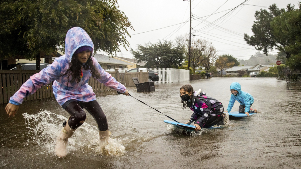 Gyerekek játszanak a heves esőzések által elöntött utcák egyikén a San Franciscótól északra fekvő Mill Valley településen 2021. október 24-én. Rendkívül heves ciklon csapott le Észak-Kaliforniára, ahol korábban erdőtüzek tomboltak. Az erős vihar sárcsuszamlásokat váltott ki és elektromos vezetékeket szakított le.