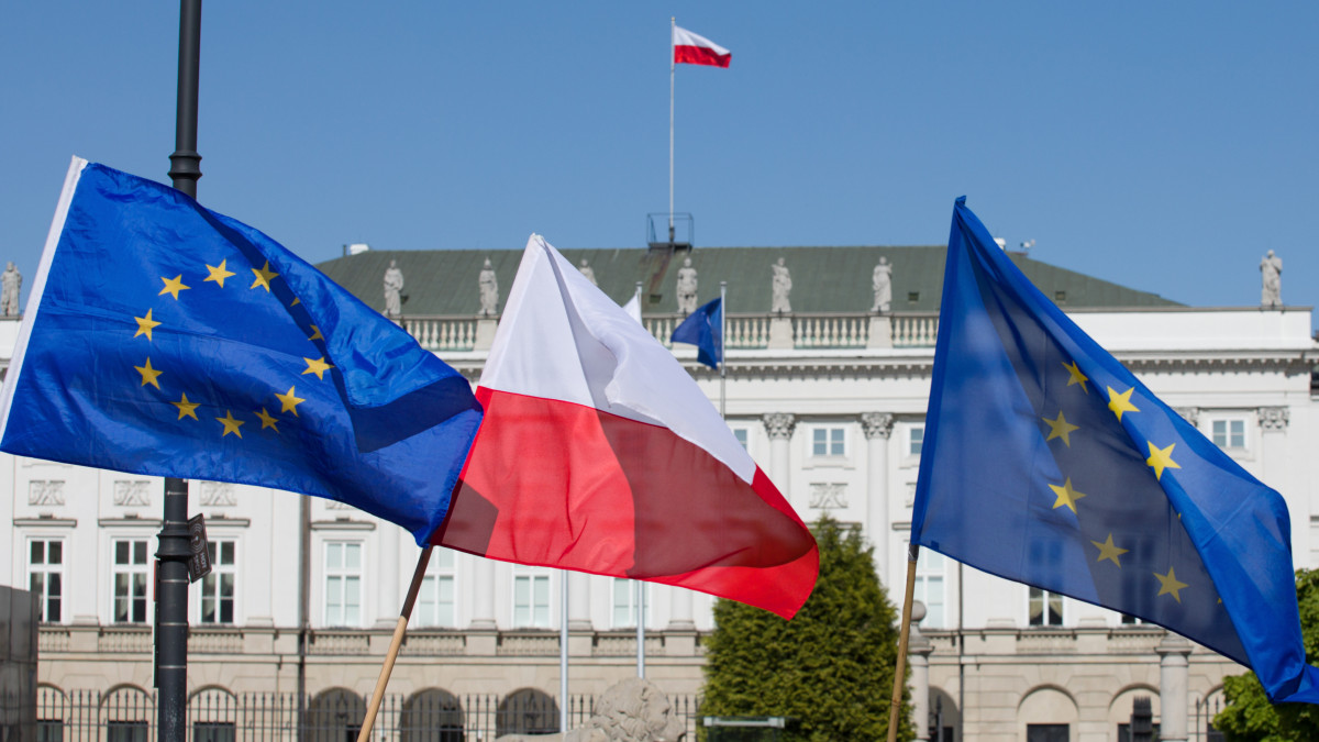 Flag of Poland and the European Union flag against the background of the Presidential Palace in Warsaw.