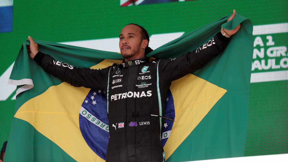 Lewis Hamilton, a Mercedes brit címvédője brazil zászlóval a pódiumon, miután győzött a Forma-1-es autós gyorsasági világbajnokság brazil Nagydíján a Sao Pauló-i Interlagos pályán 2021. november 14-én.