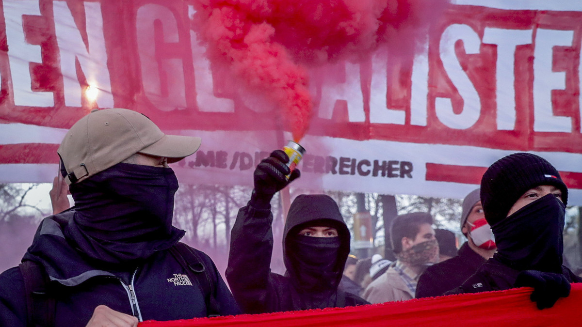 Füstgránátot tartanak a koronavírus-járvány megfékezését szolgáló korlátozások ellen tüntetők Bécsben 2021. november 20-án. Alexander Schallenberg osztrák kancellár az előző napon bejelentette, hogy Ausztriában a koronavírus gyors terjedése miatt november 22-től teljes lezárást rendel el a kormány, 2022. február 1-jétől pedig kötelező lesz a védőoltás az országban.