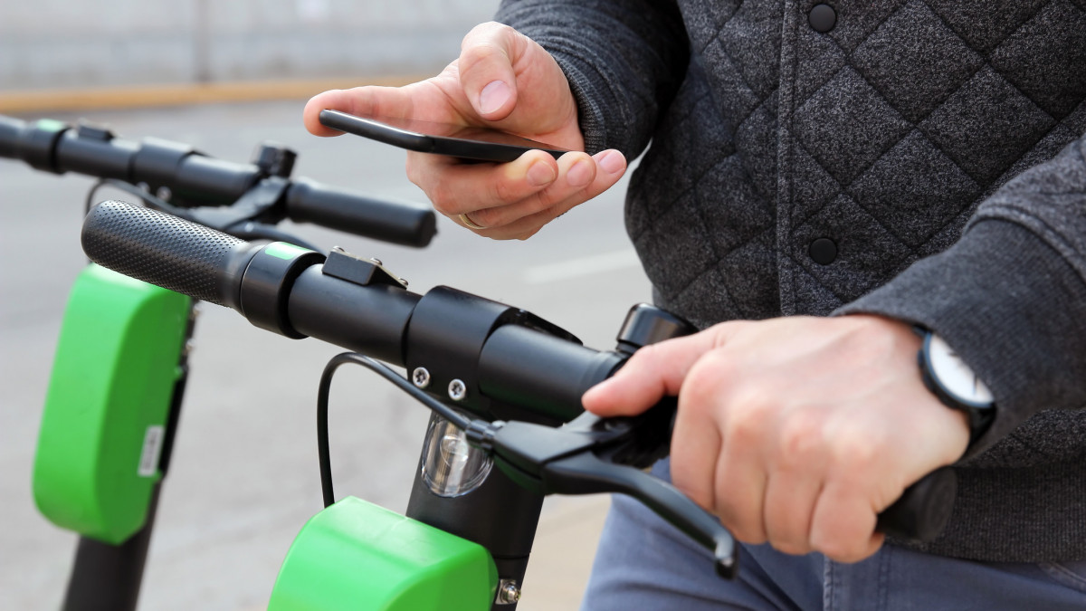 Close up image of a man on an electric scooter paying online