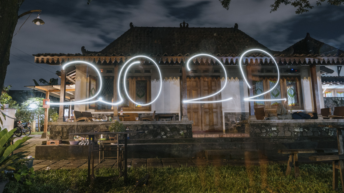 YOGYAKARTA, INDONESIA - JANUARY 01: A man using light stream marks the number 2022 during New Years Eve celebrations at home on January 1, 2022 in Yogyakarta, Indonesia. Indonesia imposed restrictions on the New Year Eve in anticipattion of coronavirus Omicron variant. (Photo by Ulet Ifansasti/Getty Images)