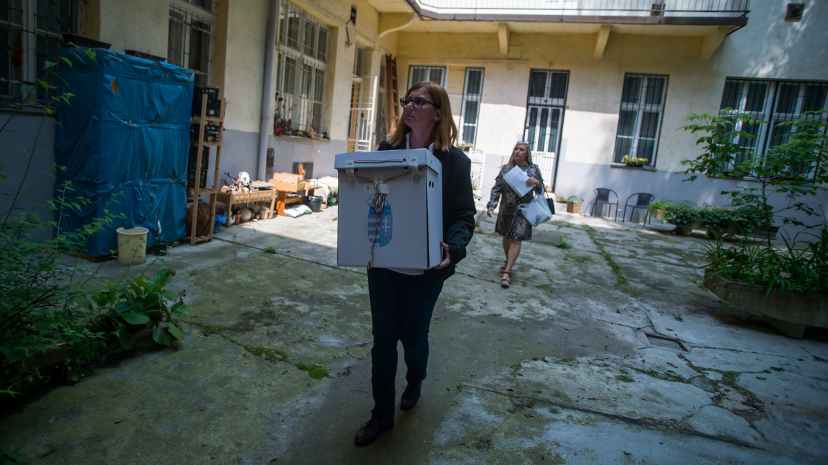A szavazatszámláló bizottság munkatársa mozgóurnát visz az európai parlamenti választáson egy VII. kerületi ház udvarán 2019. május 26-án.
