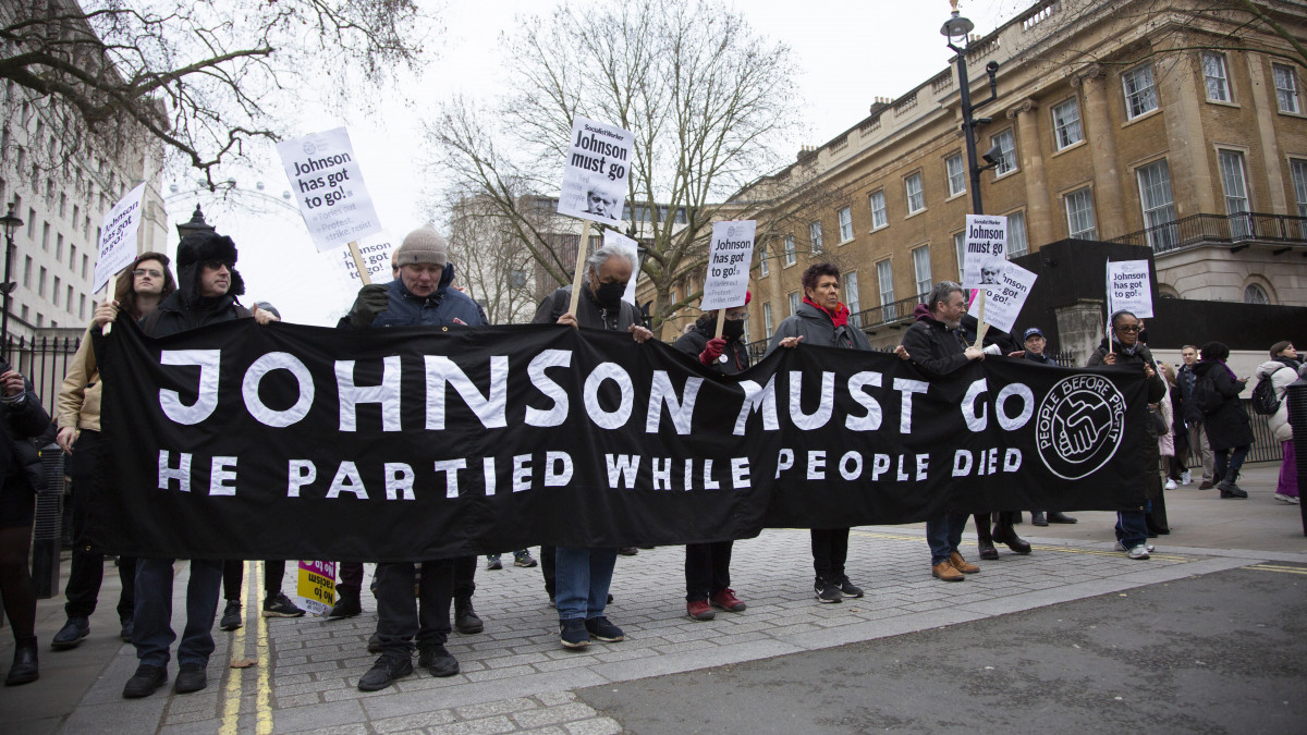 LONDON, UK - JANUARY 15: People protest against Prime Minister of the United Kingdom Boris Johnson outside the Prime Ministers Office on 10 Downing Street in London, United Kingdom on January 15, 2022. Protesters demanded the resignation of Johnson and protested against him for violating coronavirus (COVID-19) measures in a garden party. Protesters held banners reading Johnson Must Go, No To Racism - No To Boris Johnson, Johnson Has Got to Go. (Photo by Rasid Necati Aslim/Anadolu Agency via Getty Images)