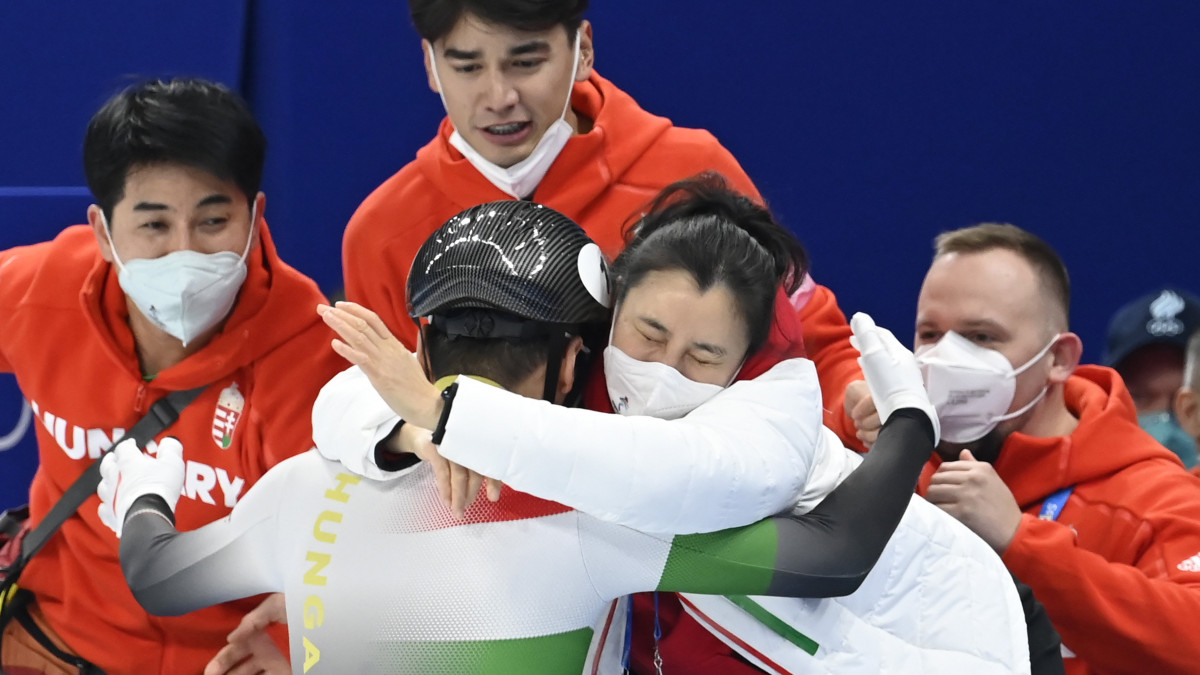 A győztes Liu Shaoangot (háttal) köszöntik, jobbról Csang Csing Lina vezetőedző (j2) és Liu Shaolin Sándor (k), Liu Shaoang testvére a férfi rövidpályás gyorskorcsolyázók 500 méteres versenyének döntője után a Fővárosi Fedett Stadionban a pekingi téli olimpián 2022. február 13-án.
