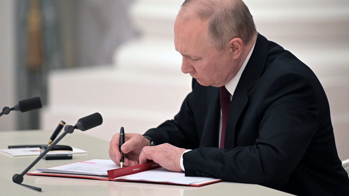 Vlagyimir Putyin orosz elnök aláírja a két önhatalmúlag kikiáltott délkelet-ukrajnai szakadár terület - a Luhanszki Népköztársaság és a Donyecki Népköztársaság - függetlenségének elismeréséről szóló dokumentumot a moszkvai Kremlben 2022. február 21-én.