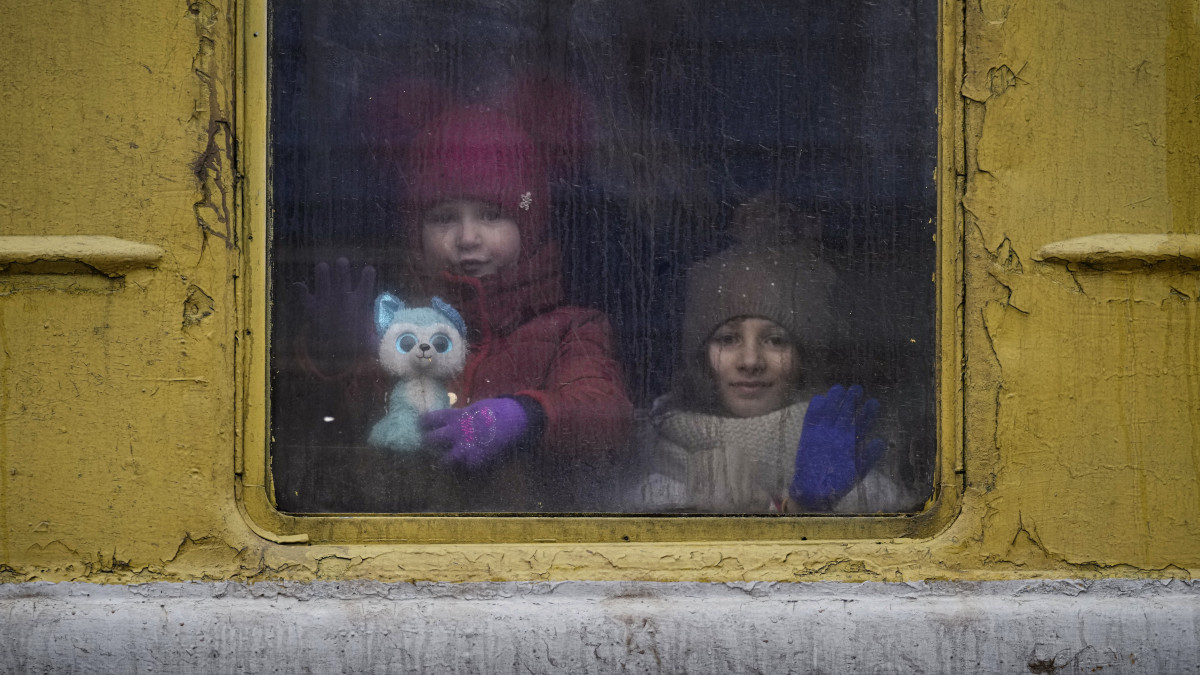 Gyerekek néznek ki a Kijevből a nyugat-ukrajnai Lvivbe induló vonat ablakán 2022. március 3-án. Vlagyimir Putyin orosz elnök február 24-én rendelte el katonai művelet végrehajtását Ukrajnában.