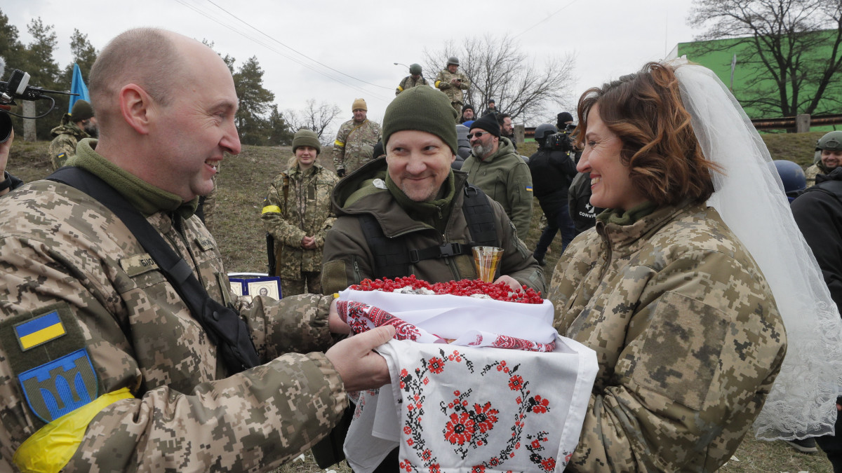 Házasságot köt Valerij és Leszja, az ukrán területvédelmi alakulatok két tagja egy Kijev melletti támaszponton 2022. március 6-án. Vlagyimir Putyin orosz elnök február 24-én rendelte el katonai művelet végrehajtását Ukrajnában.
