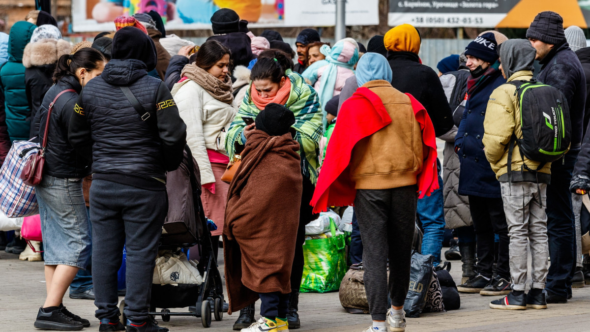 Az orosz-ukrán háború elől menekülők várakoznak az ungvári vasútállomás előtt 2022. március 9-én. A pályaudvarra érkező menekülteket buszokkal szállítják tovább a kárpátaljai városhoz közeli szlovák és magyar határátkelőhelyekre.