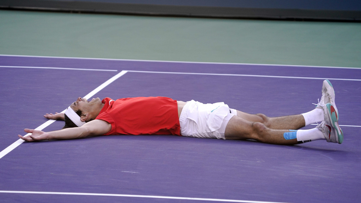 Az amerikai Taylor Fritz a földön, miután legyőzte a spanyol Rafael Nadalt az Indian Wells-i keménypályás tenisztorna férfi egyesének döntőjében 2022. március 20-án.