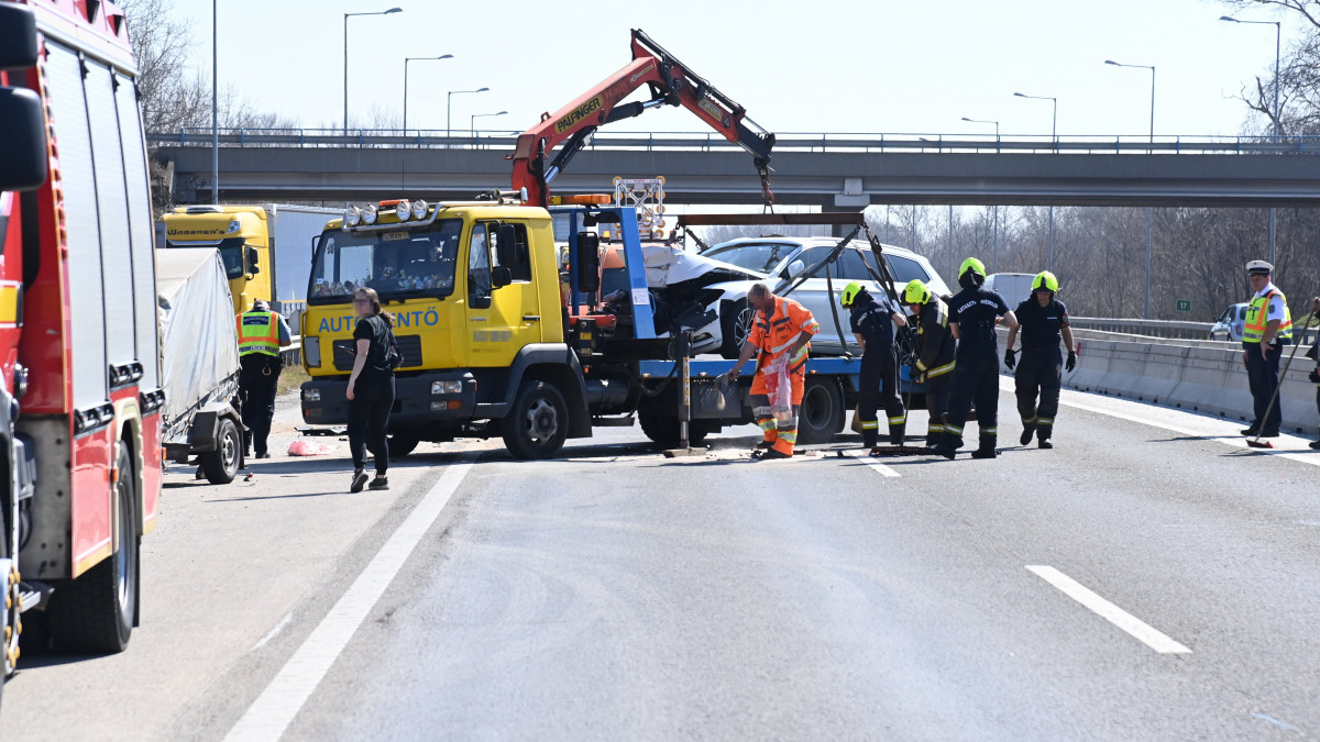 Összeroncsolódott személyautót szállítank el az M5-ös autópálya főváros felé vezető oldalán, Budapest határában, a 17-es kilométernél, ahol a gépjármű összeütközött egy tehergépkocsival 2022. március 24-én. A balesetnek van sérültje.