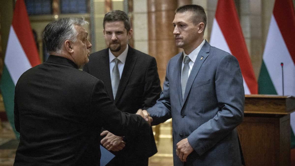 A Miniszterelnöki Sajtóiroda által közreadott képen Orbán Viktor miniszterelnök, a Fidesz elnöke és parlamenti képviselője (b) átveszi megbízólevelét Téglási Andrástól, a Nemzeti Választási Bizottság (NVB) elnökétől (k) és Nagy Attilától, a Nemzeti Választási Iroda (NVI) elnökétől az országgyűlési választáson listás mandátumot szerzett képviselők megbízólevelének ünnepélyes átadásán az Országház kupolacsarnokában 2022. április 20-án.